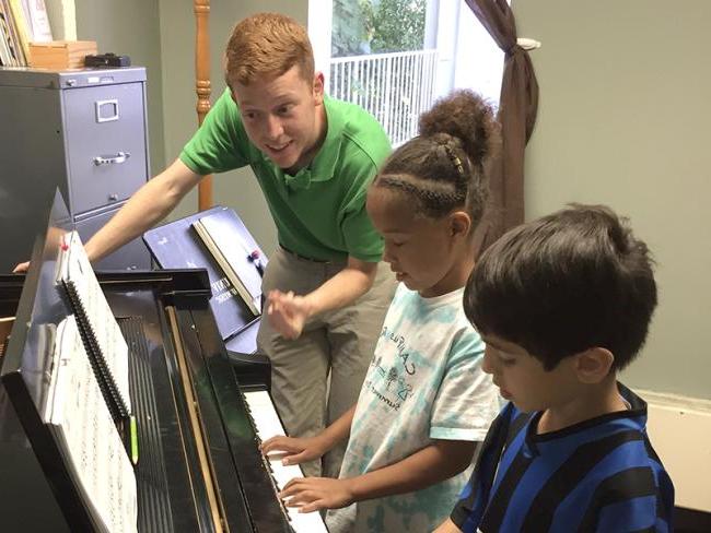 一位bet8九州登录入口的学生给孩子们上私人钢琴课